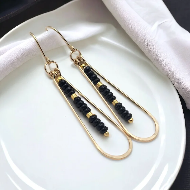 gold earrings with peridot stones -Long Gold Teardrop Hoop Earrings with Black Seed Beads